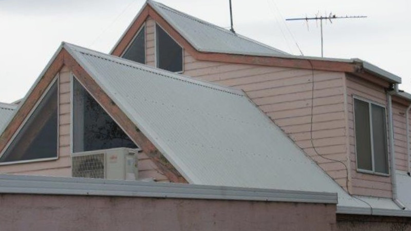 Red cement roof after moss treatment, showing clean surface