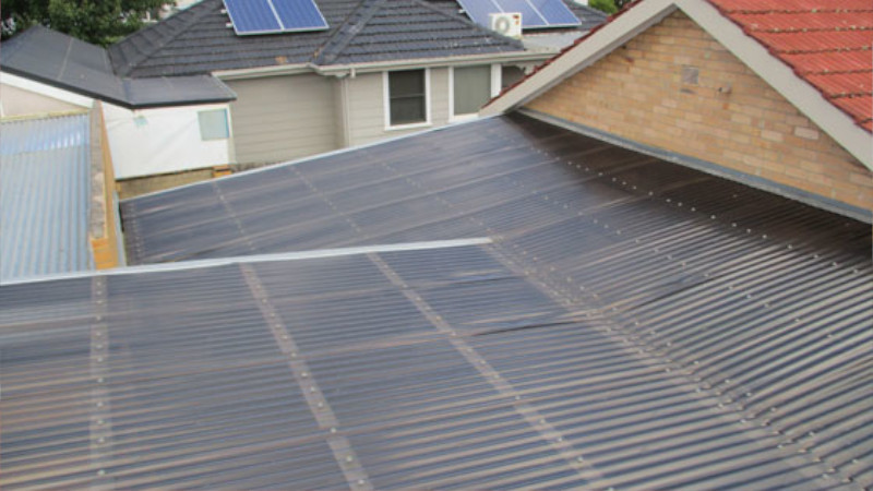 Red cement roof before moss treatment showing moss growth