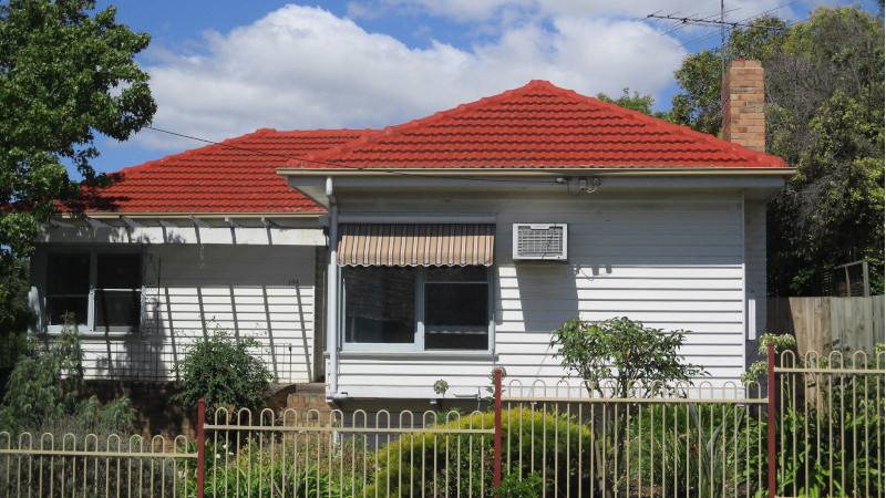 Red cement roof after moss treatment, showing clean surface